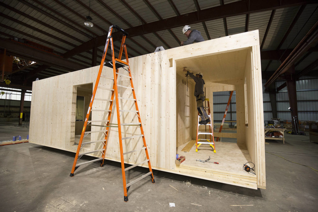 Carpenters from Switzerland build the first modular home made from cross-laminated timber inside a warehouse on Marine View Drive in Everett. (Andy Bronson / The Herald)
