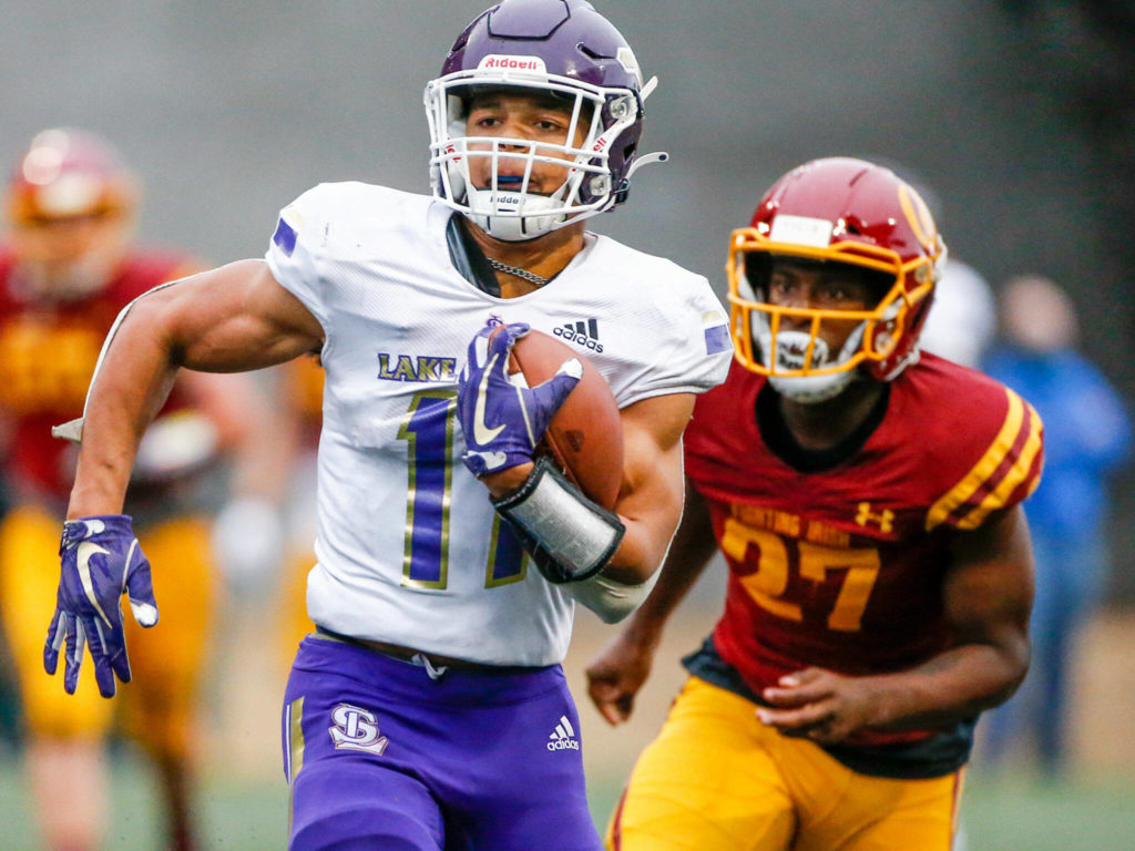 Lake Stevens’ Jayden Limar races for additional yardage after a reception with O’Dea’s Trey Stokes trailing Friday at Memorial Stadium in Seattle on September 17, 2021. The Vikings defeated the Irish, 20-3. (Kevin Clark / The Herald)
