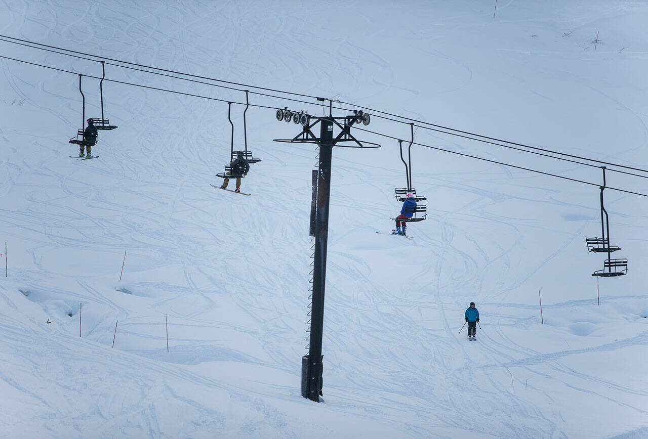 People ride the chair lift during last year’s Dec. 4 opening day at Steven’s Pass. (Olivia Vanni / Herald file)