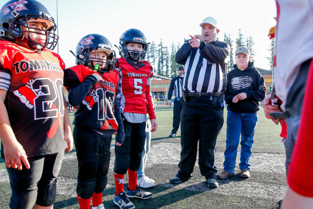 Referee and organizer Preston Dwoskin conducts the coin toss before the start of the Buddy Bowl Saturday at Marysville Getchell High School in Marysville. (Kevin Clark / The Herald)
