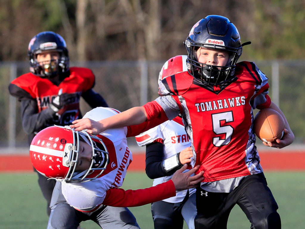 Dalton Brower (right) fends off a tackle attempt during the Buddy Bowl Saturday in Marysville. (Kevin Clark / The Herald)
