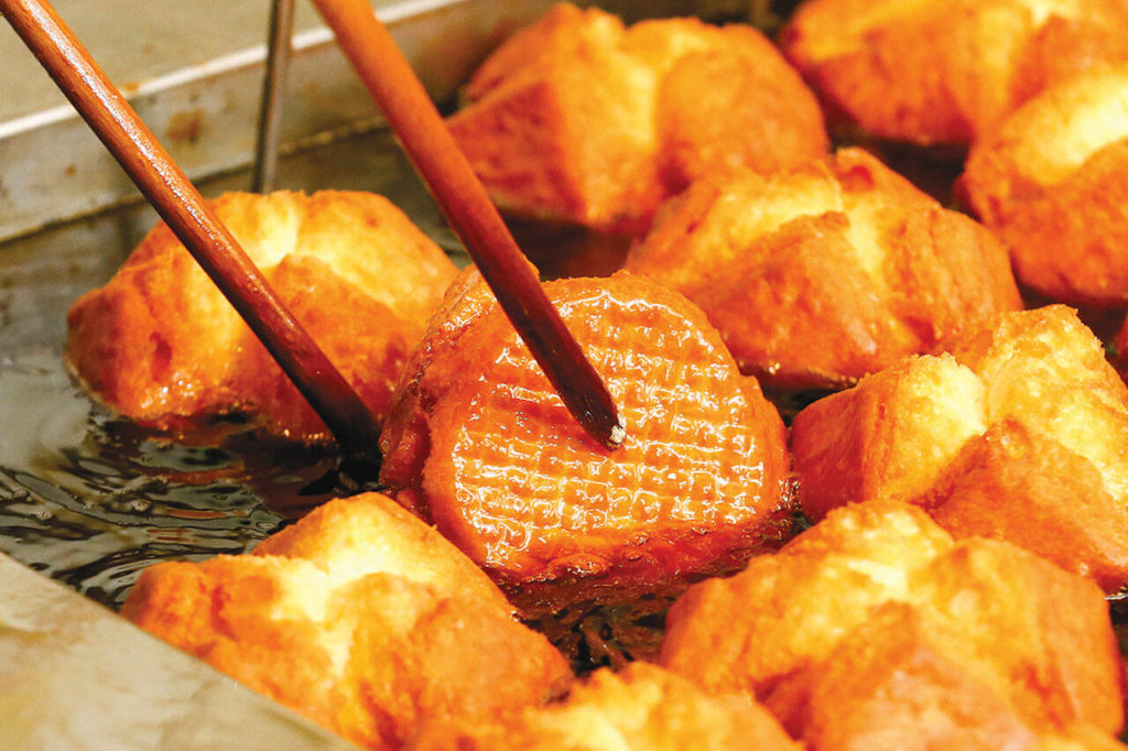 Buttermilk doughnuts hit the fryer at Donut Factory. (Kevin Clark / The Herald)

