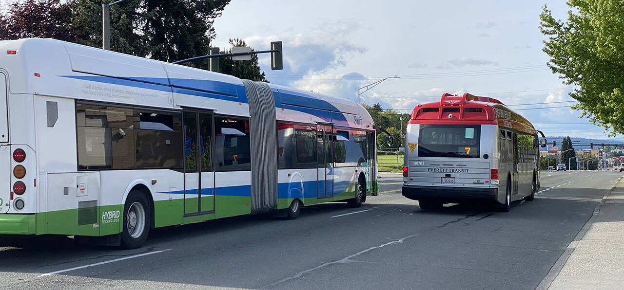 A Community Transit Swift bus and an Everett Transit bus on Rucker Avenue in Everett. (Sue Misao / Herald file)