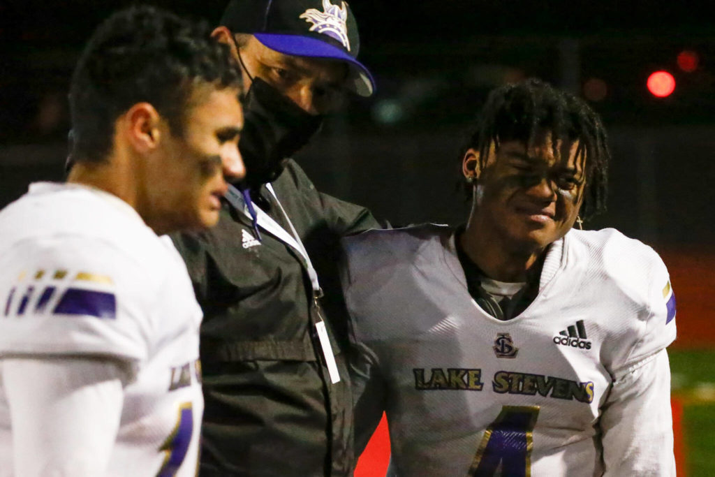 Lake Stevens’ Tom Tri, center, comforts his players Ansh Vinaya, left, and Trayce Hanks after the 4A State Championship game Saturday evening at Mt.Tahoma High School in Tacoma on December 4, 2021. The Viking lost 44-7. (Kevin Clark / The Herald)
