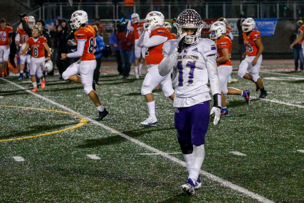 Lake Stevens star running back Jayden Limar walks off as Graham-Kapowsin players celebrate their program’s first-ever state title. (Kevin Clark / The Herald)
