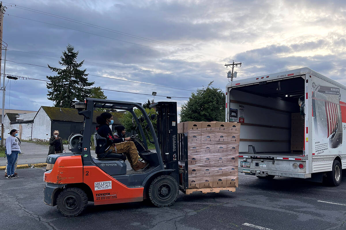 Team members from C3 and Modest Family Solution unload boxes of produce from Black, Indigenous, Farmers of Color in Washington State, as a way to strengthen food sovereignty and communal care.