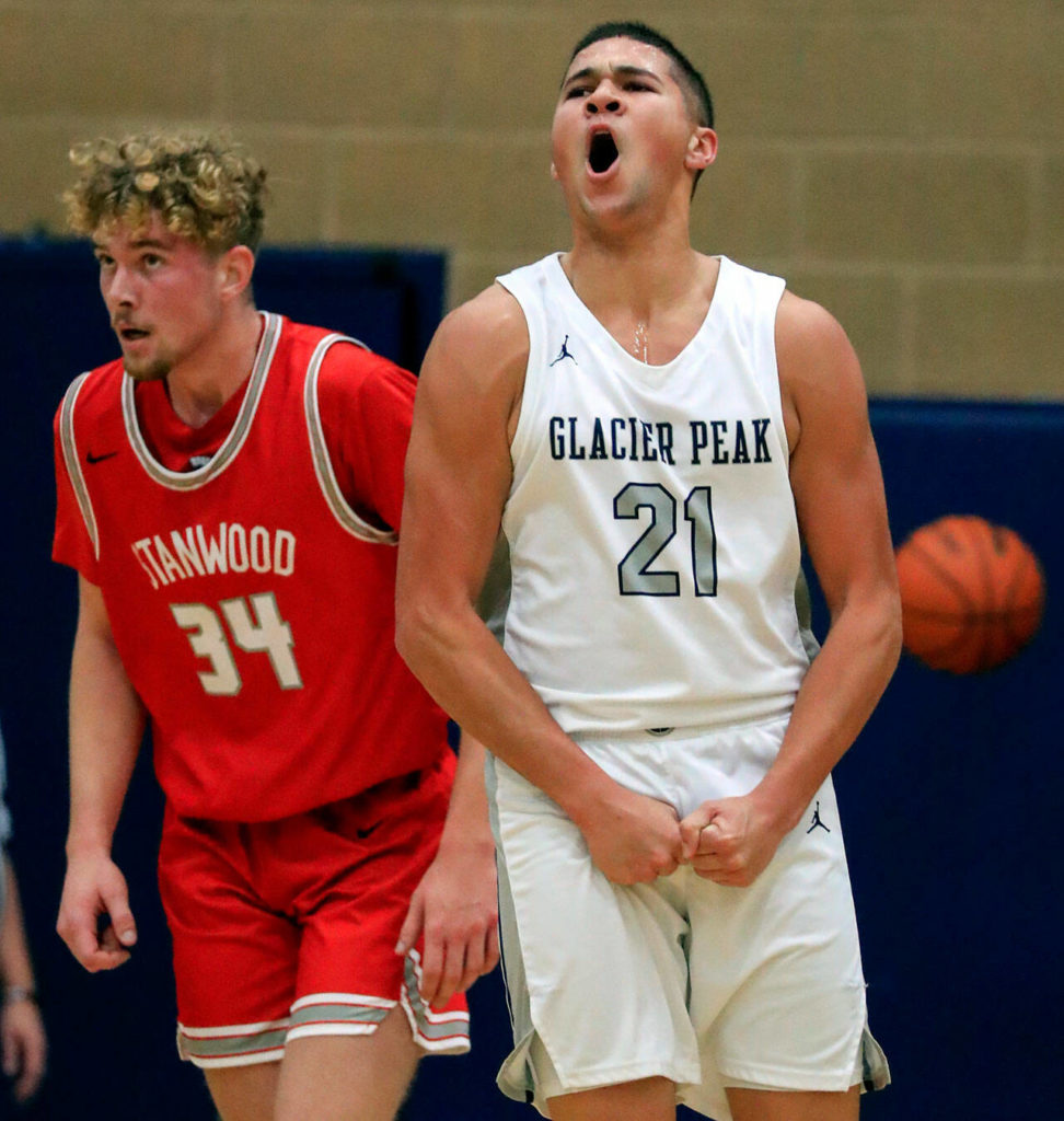 Glacier Peak’s Torey Watkins, right, celebrates a hard-fought basket with Stanwood’s Kaeden McGlothin during a game Friday evening at Glacier Peak High School in Snohomish. The Grizzlies won 66-54. (Kevin Clark / The Herald)
