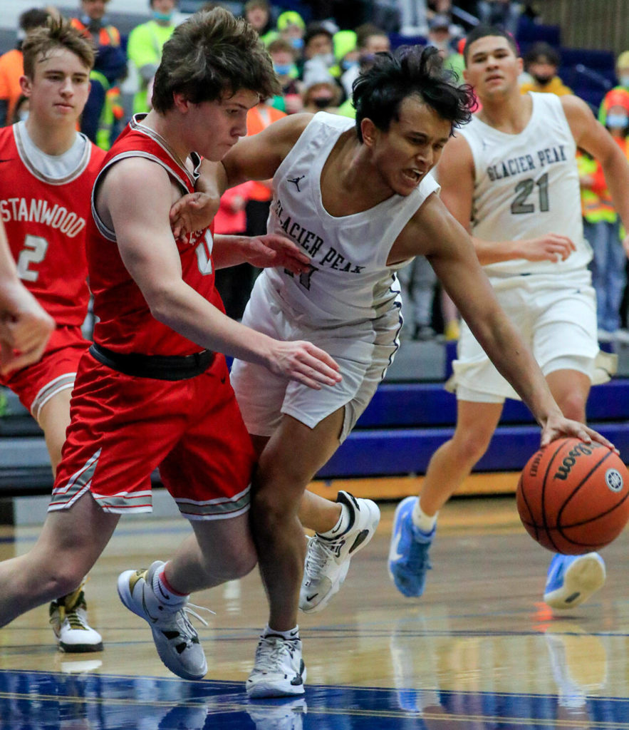 Stanwood’s Owen Thayer defends against Glacier Peak’s Adam Thomas during a game Friday evening at Glacier Peak High School in Snohomish. The Grizzlies won 66-54. (Kevin Clark / The Herald)
