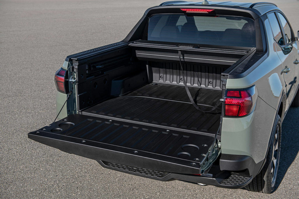 The short bed of the 2022 Hyundai Santa Cruz has a retractable hard cover, multiple storage spaces, and integrated rear bumper steps for easy access. (Manufacturer photo)
