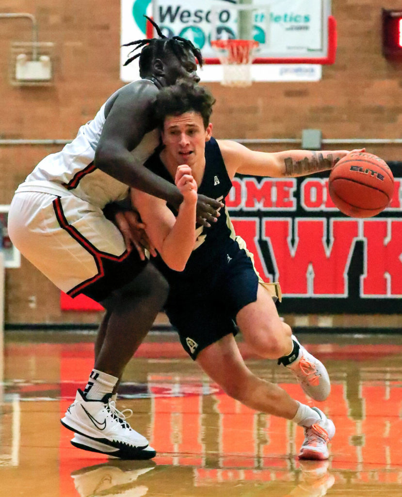 Arlington’s Grayson Falk drives the lane with Mountlake Terrace’s Zaveon Jones defending Friday evening at Mountlake Terrace High School on December 10, 2021. The Eagles won 70-55. (Kevin Clark / The Herald)
