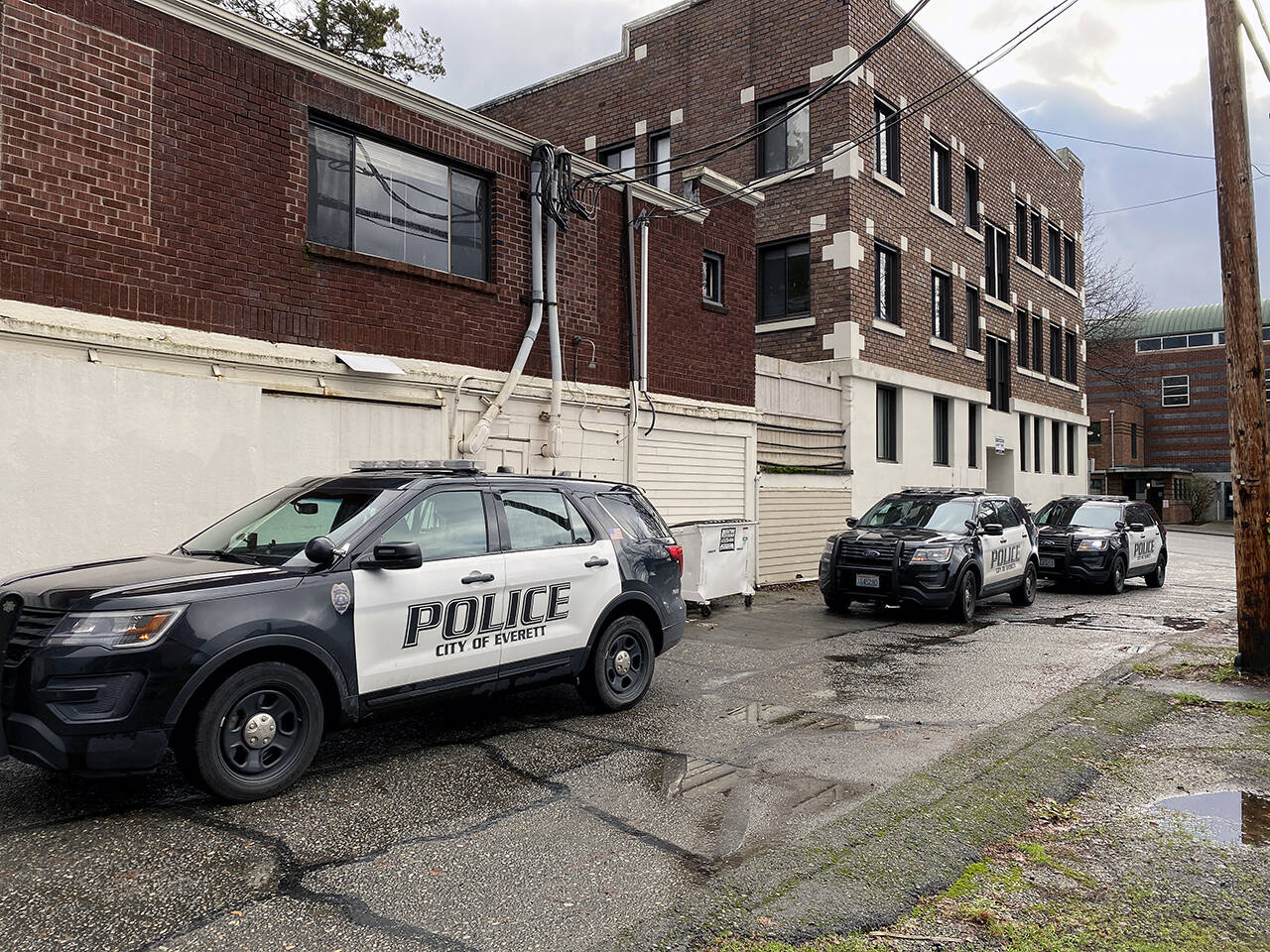 Everett police respond to a situation in an alley between Colby and Rucker avenues on Saturday. The city passed a budget that would provide for eight more police officers to be funded initially by a federal Department of Justice COPS grant. (Sue Misao / The Herald)