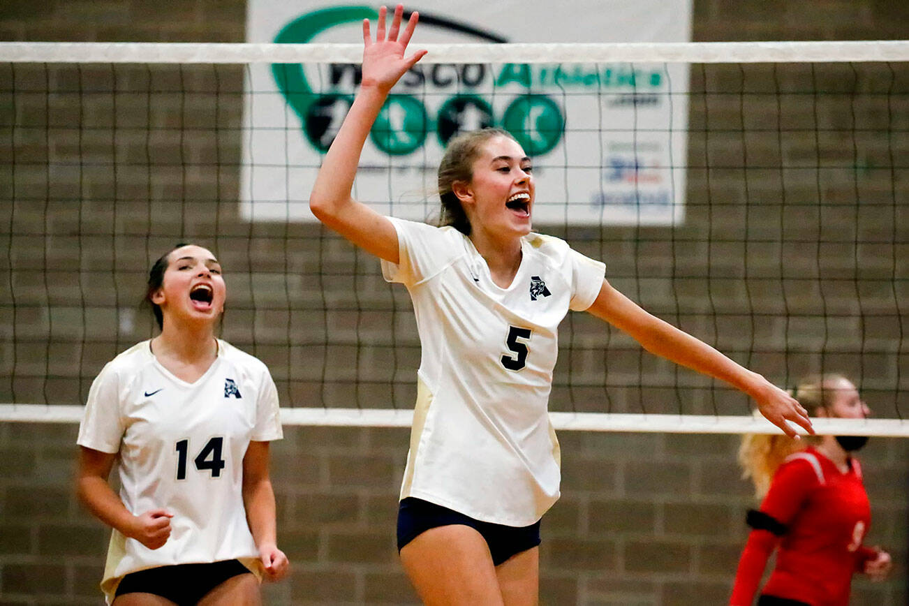 Arlington's Chloe Fochesato, left, and Arlington's Emily Mekelburg celebrate a time out by Snohomish Wednesday night at Arlington High School on September 29, 2021. The Eagles won in straight sets. (Kevin Clark / The Herald)