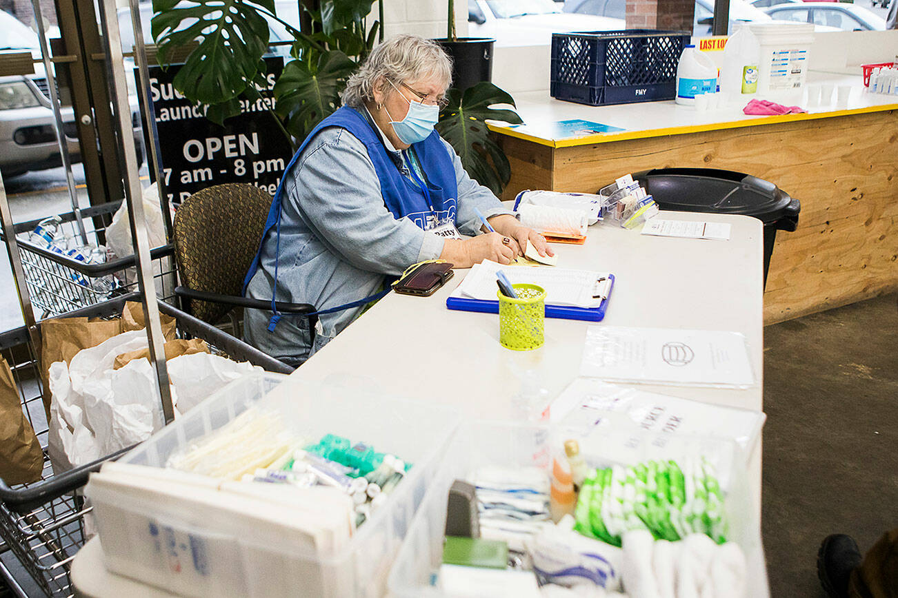 Grama Patty gets someone set up to do their laundry during North Snohomish County Outreach's Laundry Outreach on Wednesday, Dec. 1, 2021 in Arlington, Wa. (Olivia Vanni / The Herald)
