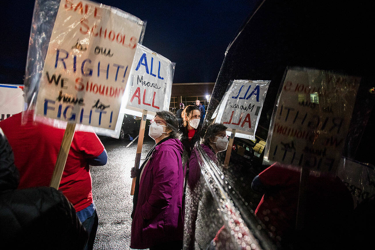 Television station lights illuminate those gathered for a rally demanding the Monroe School District address harassment and bullying problems on Monday, Dec. 13, 2021 in Monroe, Wa. (Olivia Vanni / The Herald)