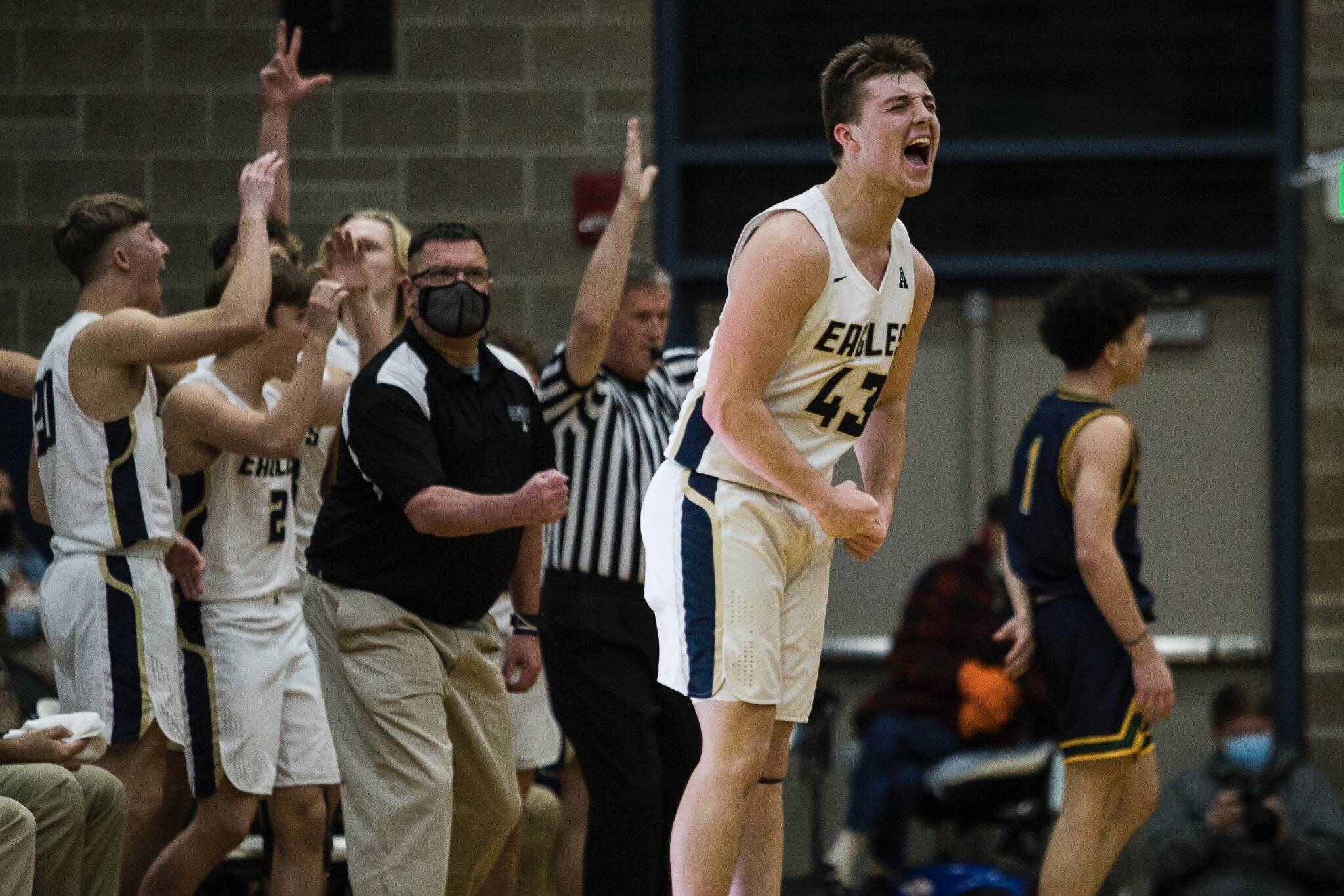 Arlington's Ethan Martin and the Arlington bench react to his three-point shot during the game against Shorecrest on Tuesday, Dec. 14, 2021 in Arlington, Wa. (Olivia Vanni / The Herald)