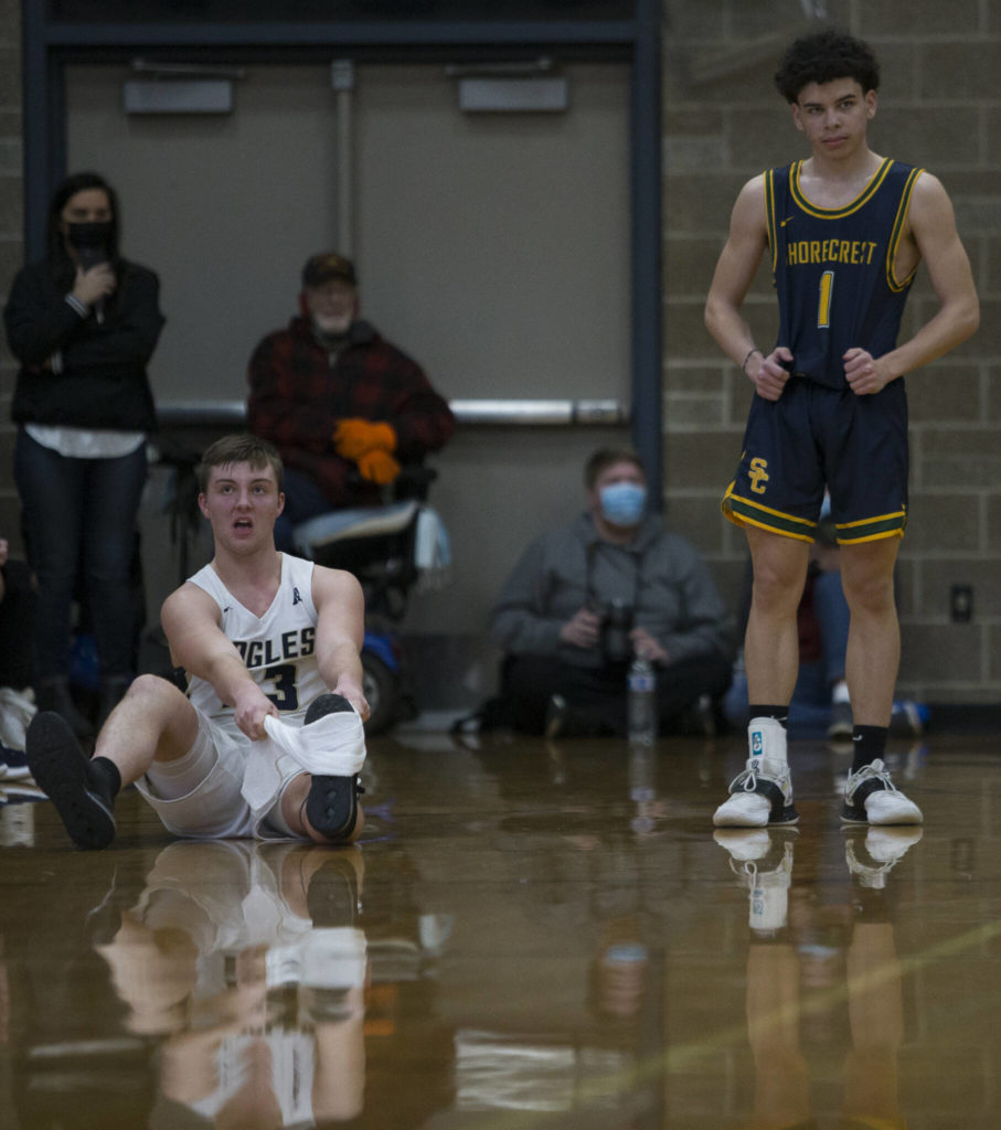 Arlington’s Ethan Martin stretches out a cramp during the game against Shorecrest on Tuesday, Dec. 14, 2021 in Arlington, Wa. (Olivia Vanni / The Herald)
