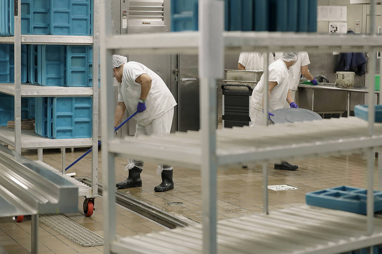 In this 2019 photo, workers are shown in the kitchen of the U.S. Immigration and Customs Enforcement detention facility in Tacoma. (AP Photo/Ted S. Warren,File)