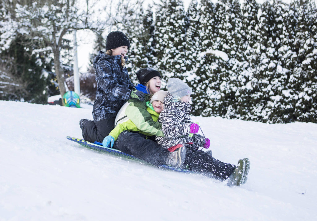 The Hansen family sleds down a hill in the View Ridge neighborhood Monday in Everett. (Olivia Vanni / The Herald)
