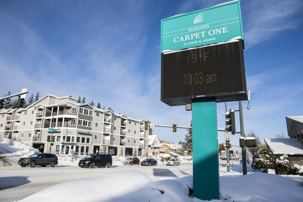 Icicles hangs from the Hatloes sign showing the current temperature and time along Rucker Avenue on Monday in Everett. (Olivia Vanni / The Herald)
