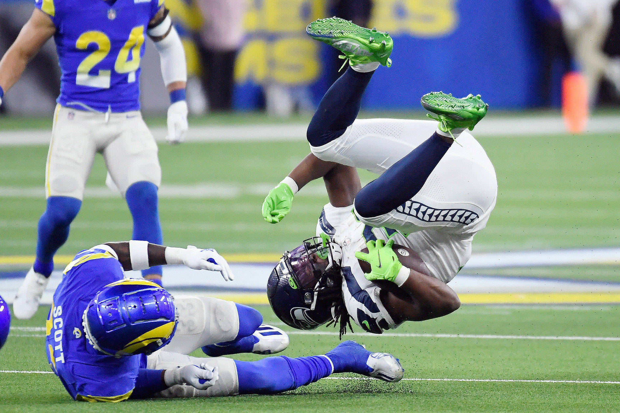 Seahawks running back DeeJay Dallas flips over as he is tackled by Rams safety Nick Scott during the second half of a game Tuesday in Inglewood, Calif. (AP Photo/Kevork Djansezian)