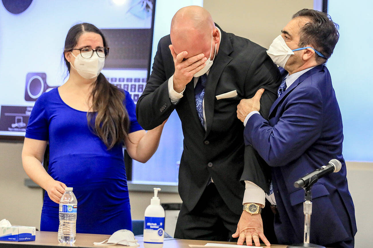 Ryan Leenders, center, reacts to the not guilty verdicts handed down by a jury with defense attorneys Samantha Sommerman, left, and Peter Mazzone, right, Thursday afternoon at the Snohomish County Superior Courthouse in Everett on December 23, 2021.  (Kevin Clark / The Herald)
