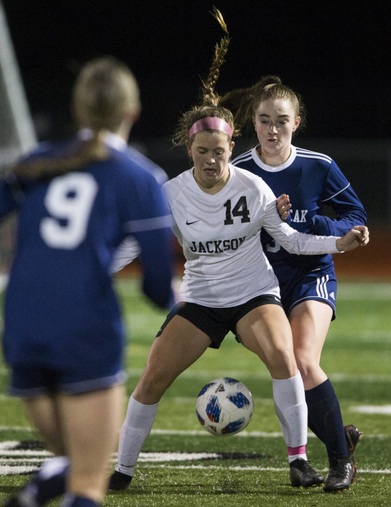 Jackson’s Kaeden Hansen and Glacier Peak’s Chloe Seelhoff fight for the ball during a game on Oct. 26, 2021 in Snohomish. (Olivia Vanni / The Herald)
