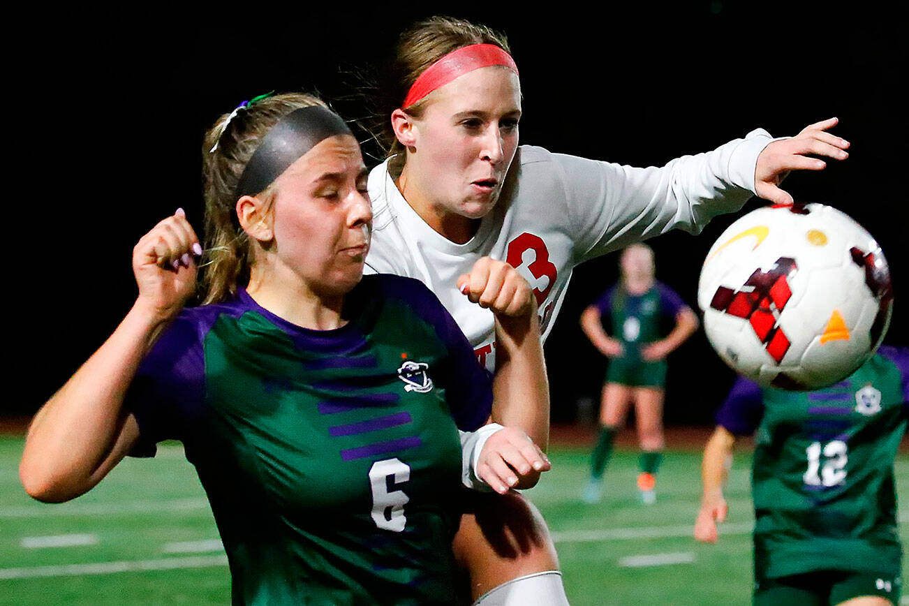 Edmonds-Woodway's Clara Miceli, left, and Snohomish's Sara Rodgers chase a throw in Thursday night at Edmonds-Woodway High School in Edmonds on October 7, 2021. (Kevin Clark / The Herald)