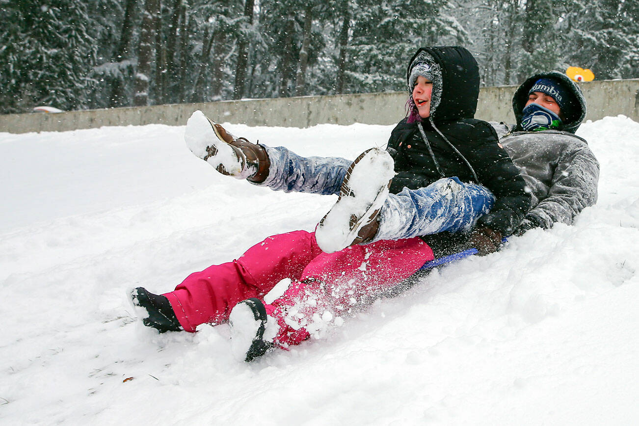 Addisyn Hager, 11, and James Hager take to the slopes of Forest Park Sunday afternoon in Everett on December 26, 2021.  (Kevin Clark / The Herald)