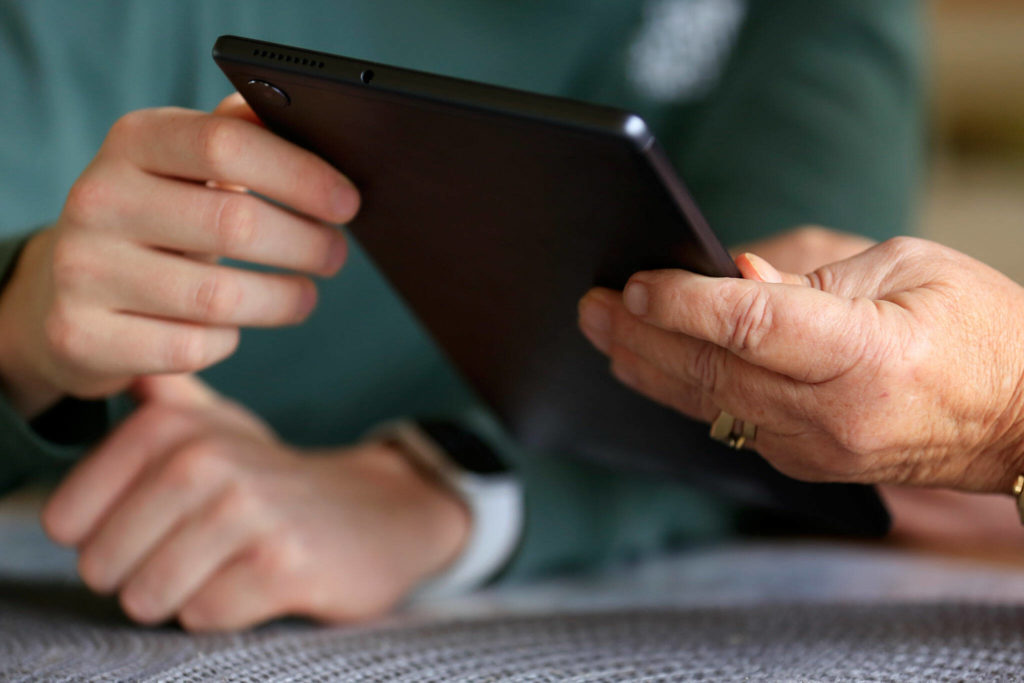 Jack Rice (left) gives his grandmother Carolyn Rice a tutorial on her new tablet. (Kevin Clark / The Herald)
