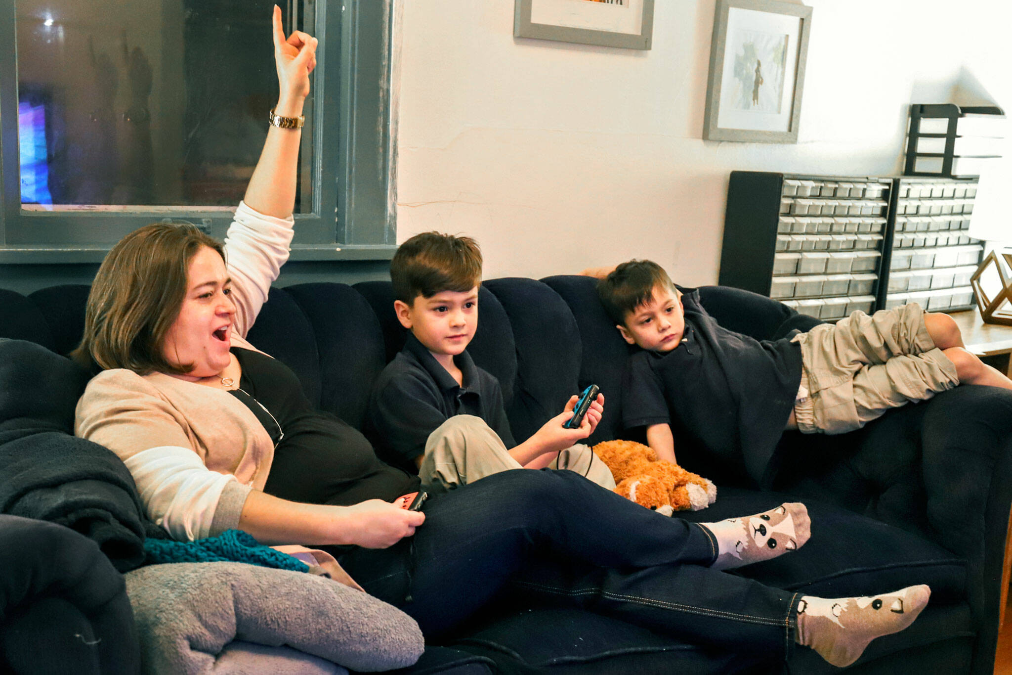 Mara Wiltshire (left) celebrates her first-place finish in Mario Cart against her son Miles Jenkins, 7, as Calvin Jenkins, 5, looks on Friday at their home in Everett. (Kevin Clark / The Herald)