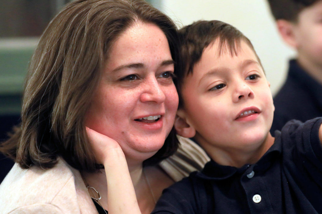 Mara Wiltshire watches video game play while cuddling with her son Calvin Jenkins, 5, Friday in Everett. (Kevin Clark / The Herald)
