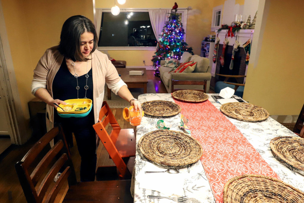 Mara Wiltshire cleans up after dinner at her home in Everett on Friday. (Kevin Clark / The Herald)
