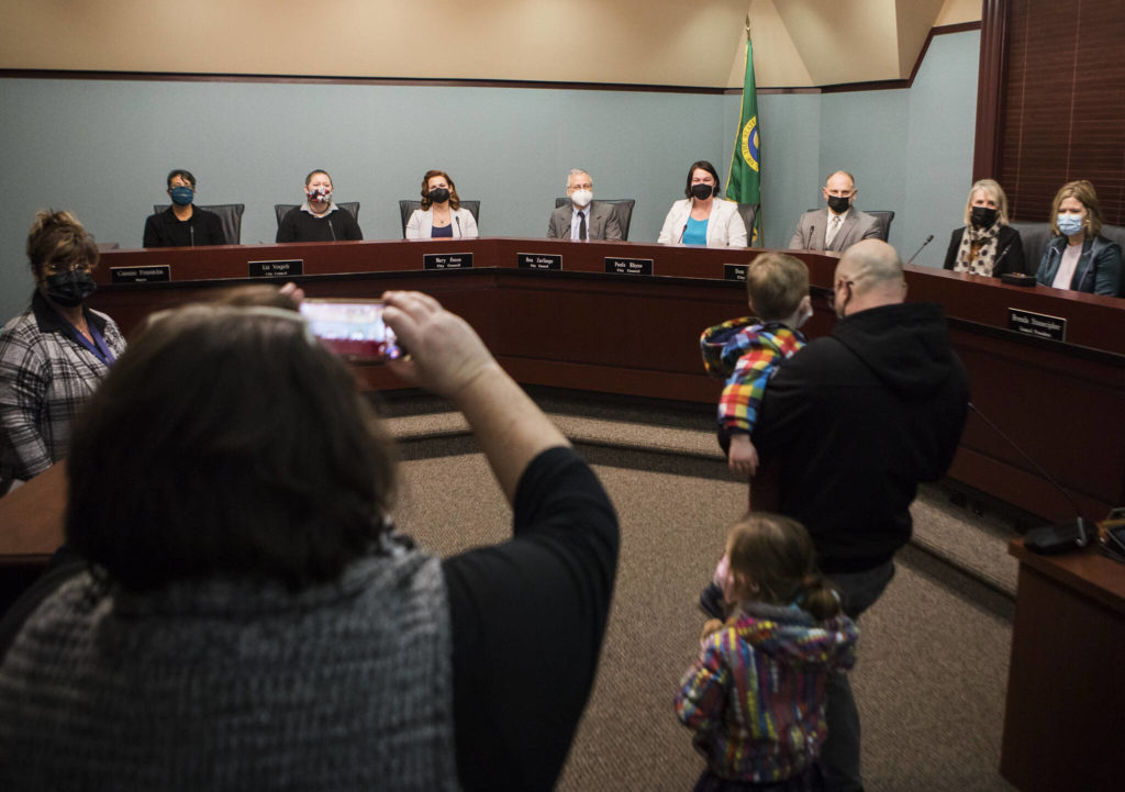 Family and friends of Everett City Council members take photos after the special meeting Monday in Everett. (Olivia Vanni / The Herald)
