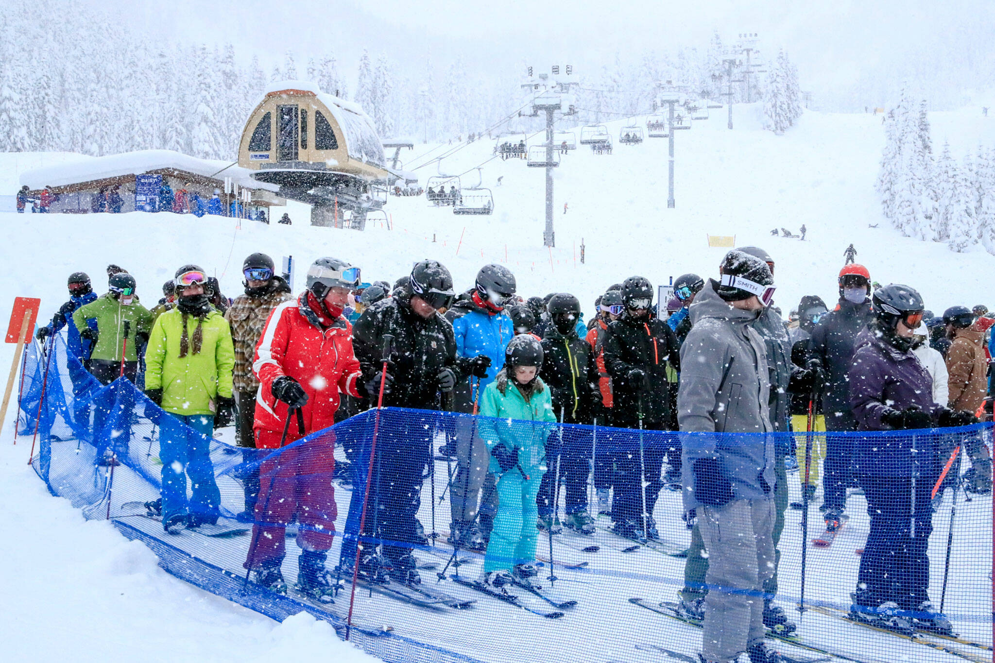 Patrons wait their turn for a chair on the lift at Stevens Pass on Thursday afternoon. (Kevin Clark / The Herald)