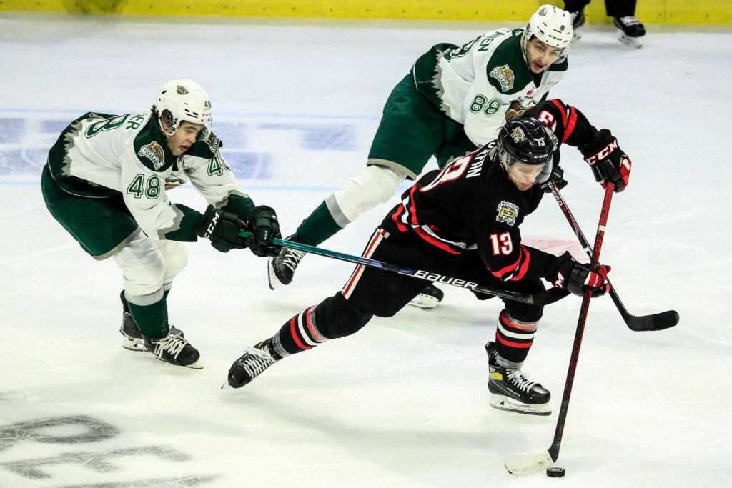 Portland’s James Stefan controls the puck with Everett’s Olen Zellweger (left) and Niko Huuhtanen trailing Saturday evening at the Angel of the Winds Arena in Everett. (Kevin Clark / The Herald)
