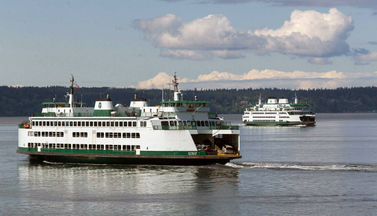 Ferries pass on a crossing between Mukilteo and Whidbey Island in August. (Andy Bronson / Herald file)