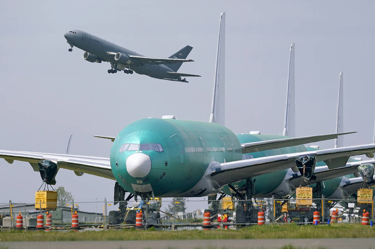 A U.S. Air Force KC-46A Pegasus jet takes off on April 23 near a line of Boeing 777X airplanes parked nose to tail on an unused runway at Paine Field, near Boeing’s production facility in Everett. (AP Photo/Elaine Thompson, File)