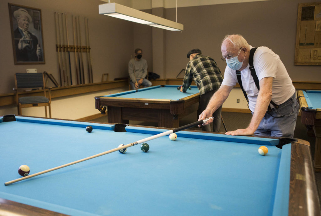 Ray King lines up his pool shot at the Carl Gipson Center on Wednesday. (Olivia Vanni / The Herald)

