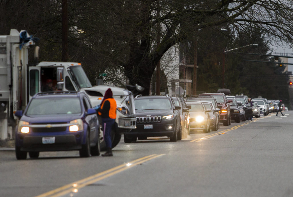 People get out of their cars along Wetmore Avenue to see how far they are from a testing site Thursday in Everett. (Olivia Vanni / The Herald)
