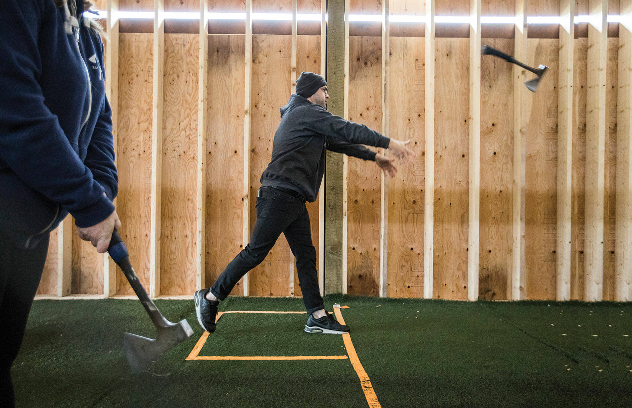 Scott Shrock demonstrates proper axe-throwing form at Arrowhead Ranch on Camano Island. (Olivia Vanni / The Herald)