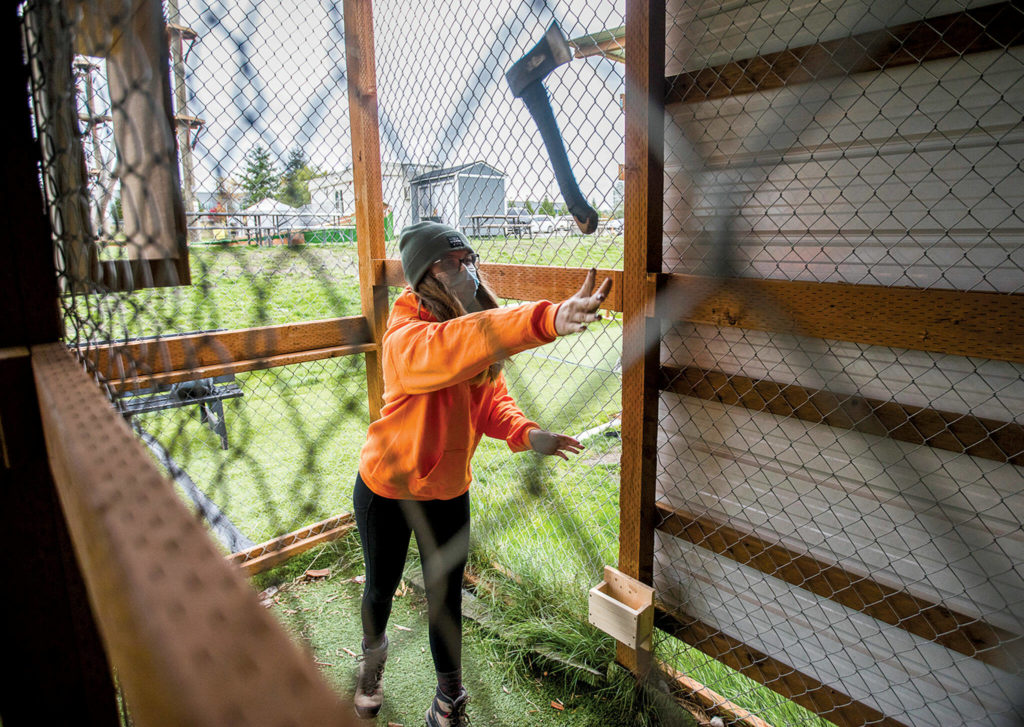 Aspen Harder tries her hand at axe throwing at High Trek Adventures in south Everett. (Olivia Vanni / The Herald)
