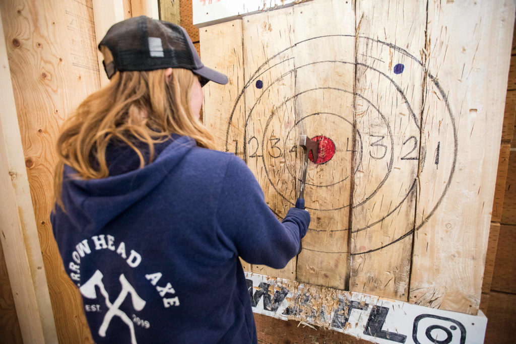 Katie Shrock pulls an axe out of a wooden bull’s-eye at Arrowhead Ranch. (Olivia Vanni / The Herald)
