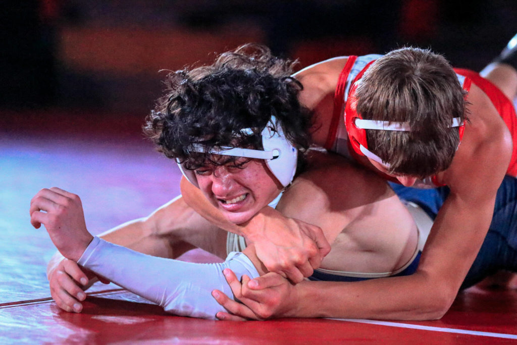 Stanwood’s Keaton Mayernik (top) wrestles Arlington’s Eric Vogel in the 138-pound weight class at Stanwood High Schoolon Thursday evening. (Kevin Clark / The Herald)
