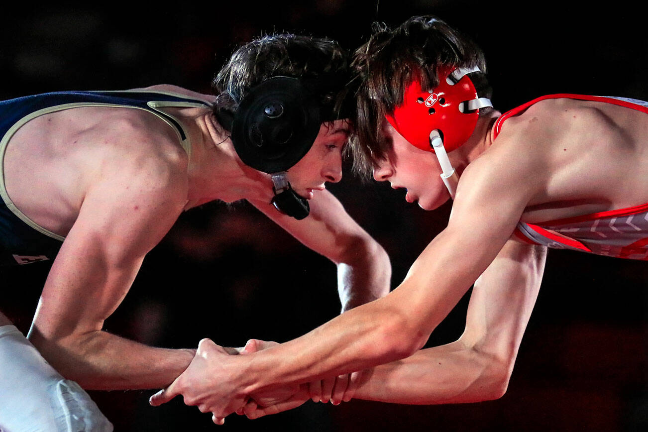 Arlington's David Forslof, left, faces on with Stanwood's Lane Ovenell in the 132lb weight class at Stanwood High School Thursday evening in Stanwood, Washington on January 6, 2022. The Spartans defeated the Eagles 50-21.  (Kevin Clark / The Herald)