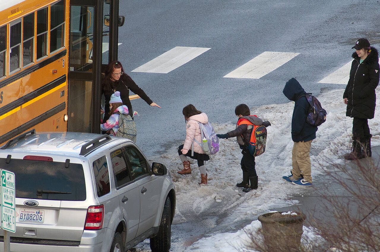 Kids board a school bus Tuesday morning in Everett. (Sue Misao / The Herald)