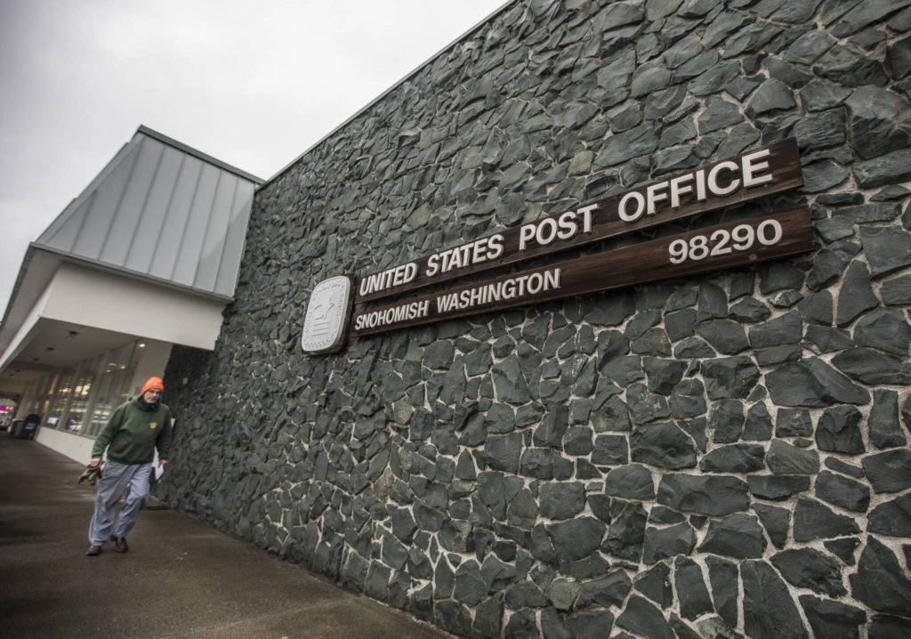People pick up mail at the Post Office in Snohomish on Wednesday. (Olivia Vanni / The Herald)
