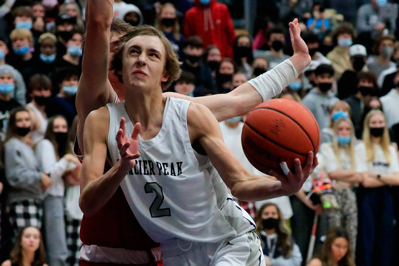 Glacier Peak's Jo Lee drives the lane with Stanwood's Mack Hepper defending Friday evening at Glacier Peak in Snohomish on December 8, 2021. The Grizzles won 66-54. (Kevin Clark / The Herald)