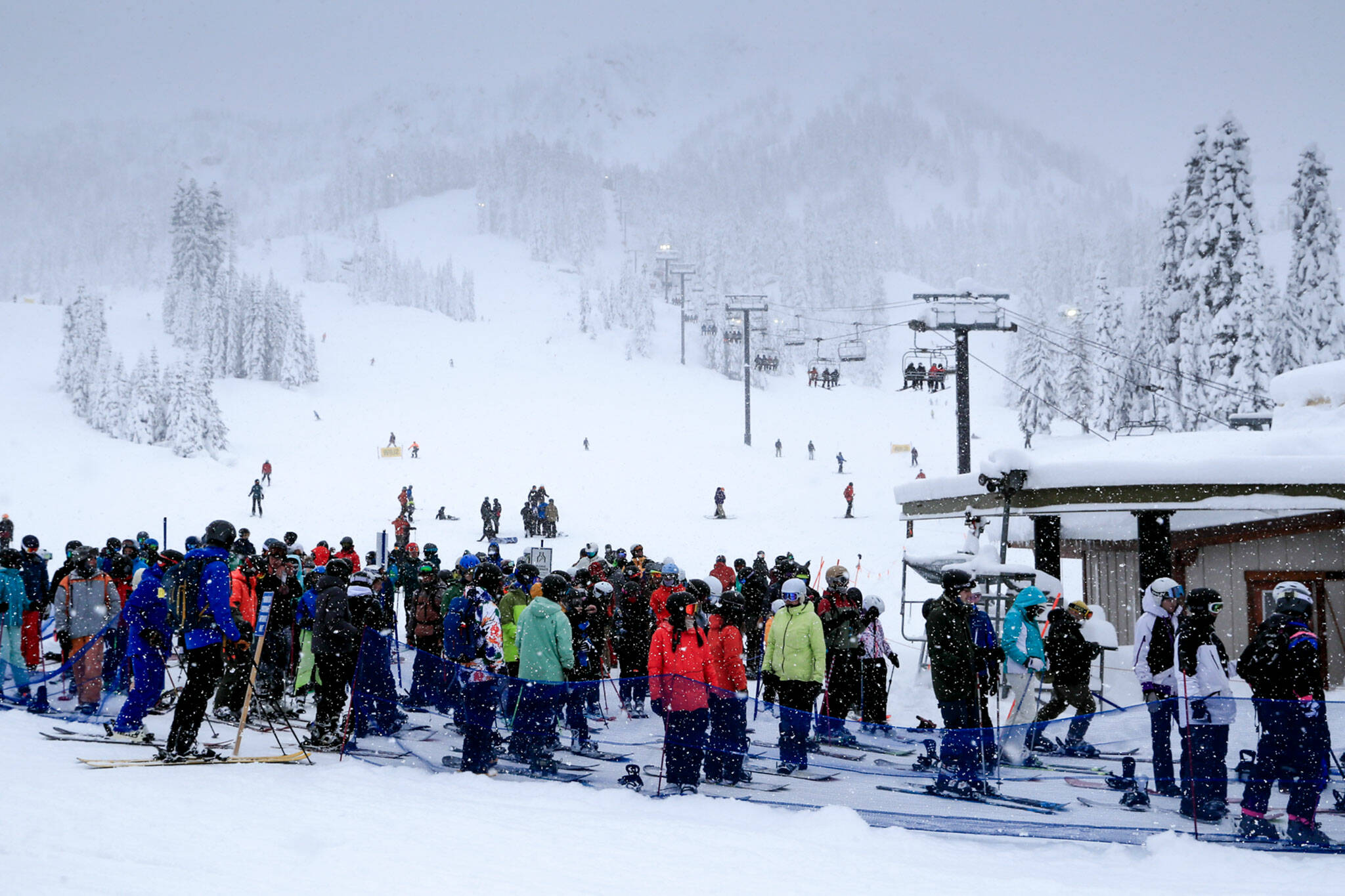 Skiers and snowboarders wait for a lift at Stevens Pass on Dec. 30. (Kevin Clark / The Herald)