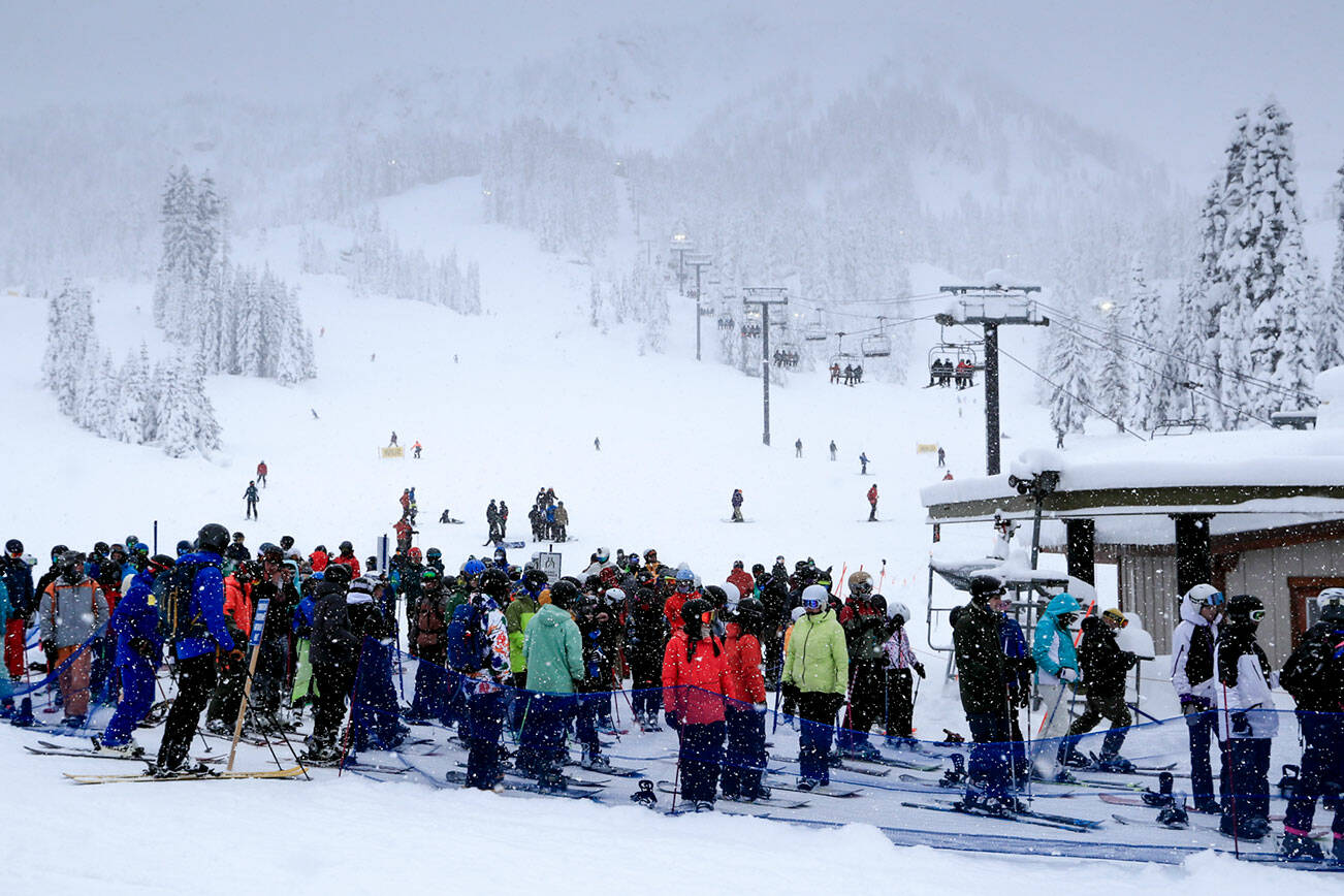 Skiers and snowboarders wait for the lift on Stevens Pass Thursday afternoon on December 30, 2021.  (Kevin Clark / The Herald)