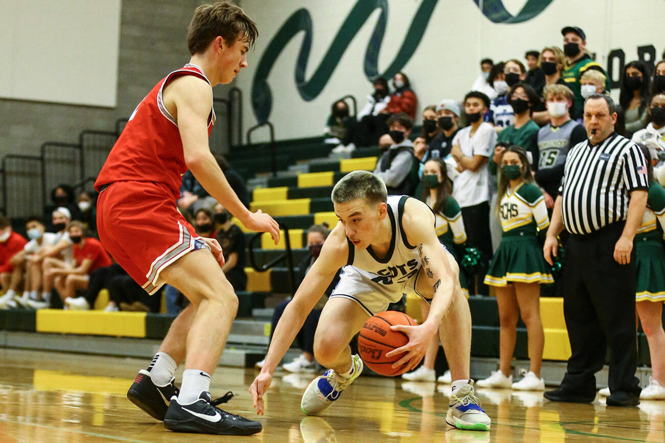 Shorecrest's Parker Baumann gathers a loose dribble with Stanwood's John Floyd defending Thursday evening at Shorecrest High School in Shoreline, Washington on January 13, 2022. The Highlanders won 88-68. (Kevin Clark / The Herald)